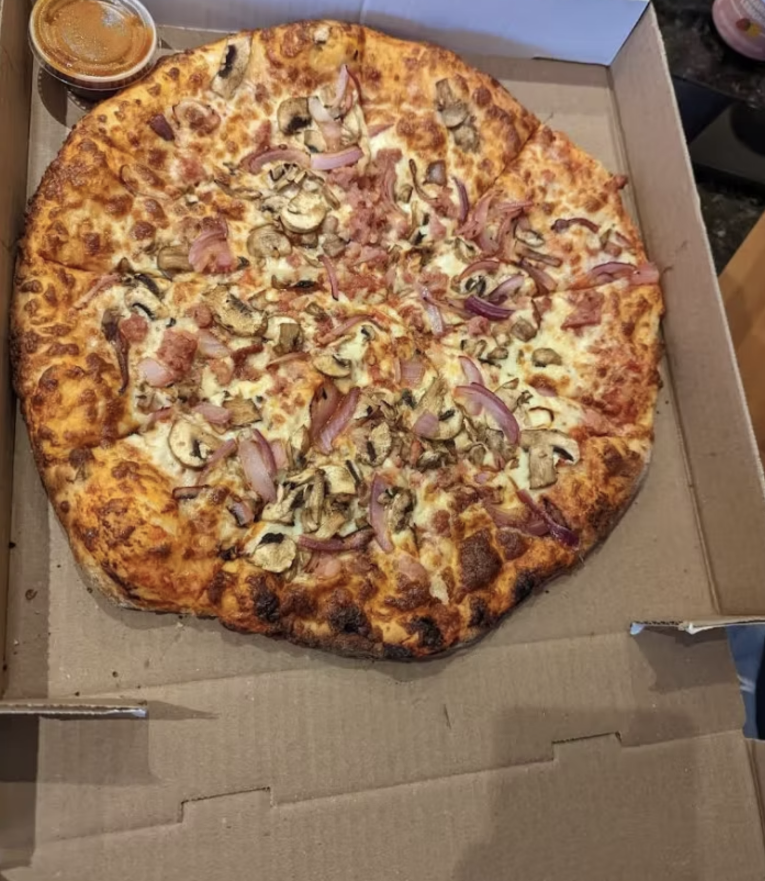 A generously topped pizza loaded with mushrooms, onions, ham and melted cheese.