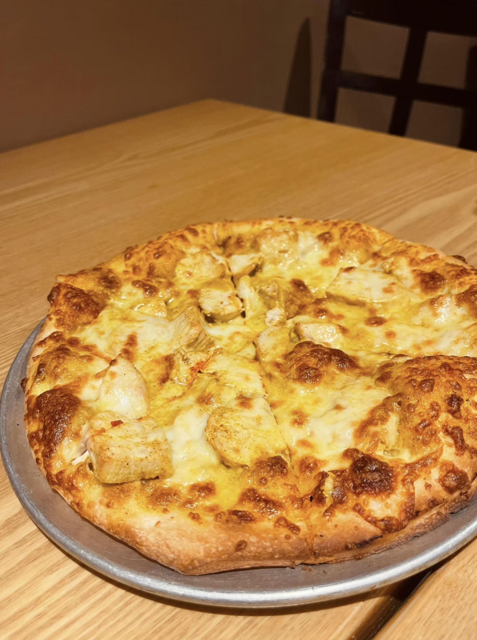 A golden chicken pizza topped with tender chicken and melted cheese.